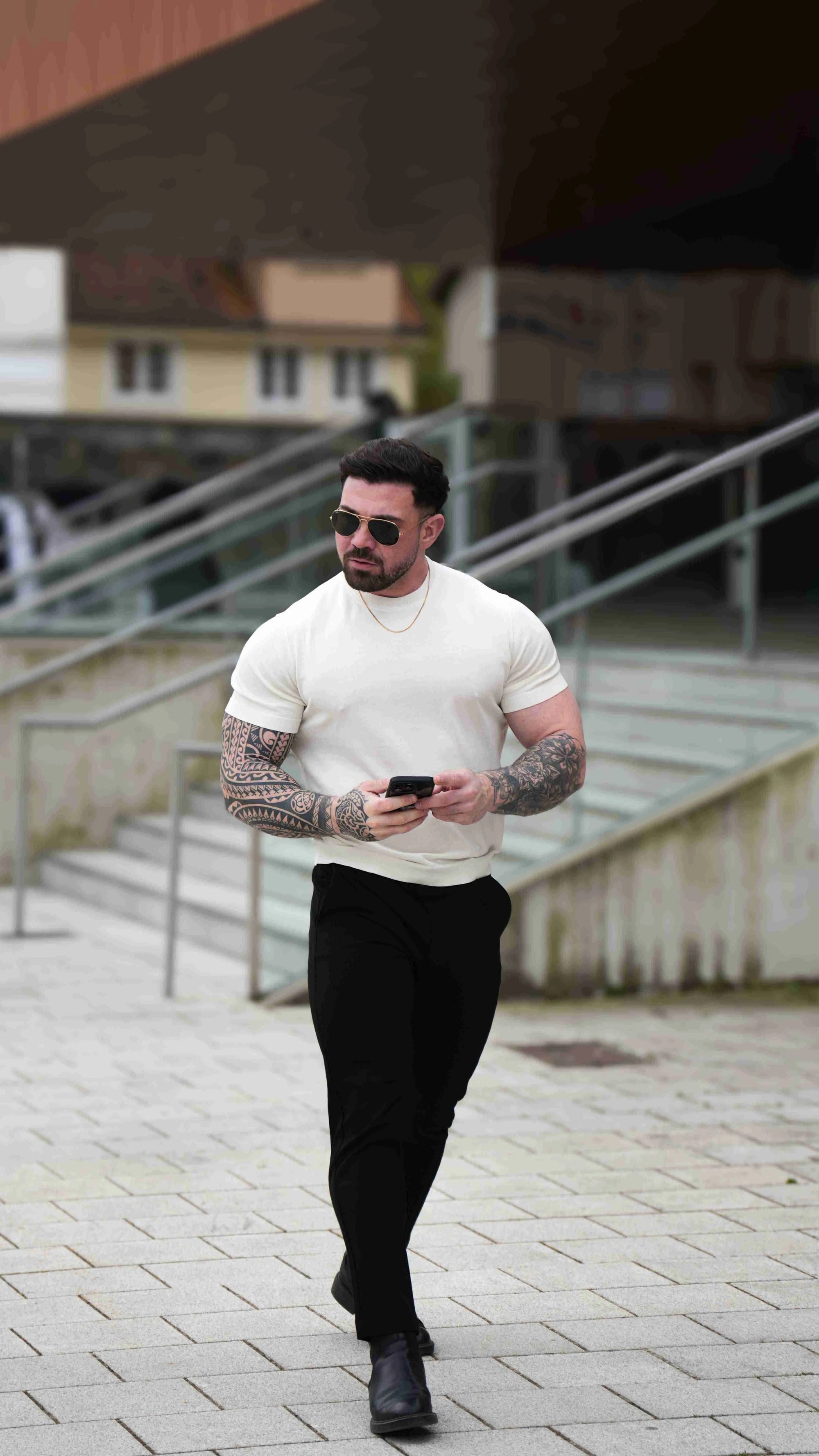 Men is wearing cream muscle-fit t-shirt.