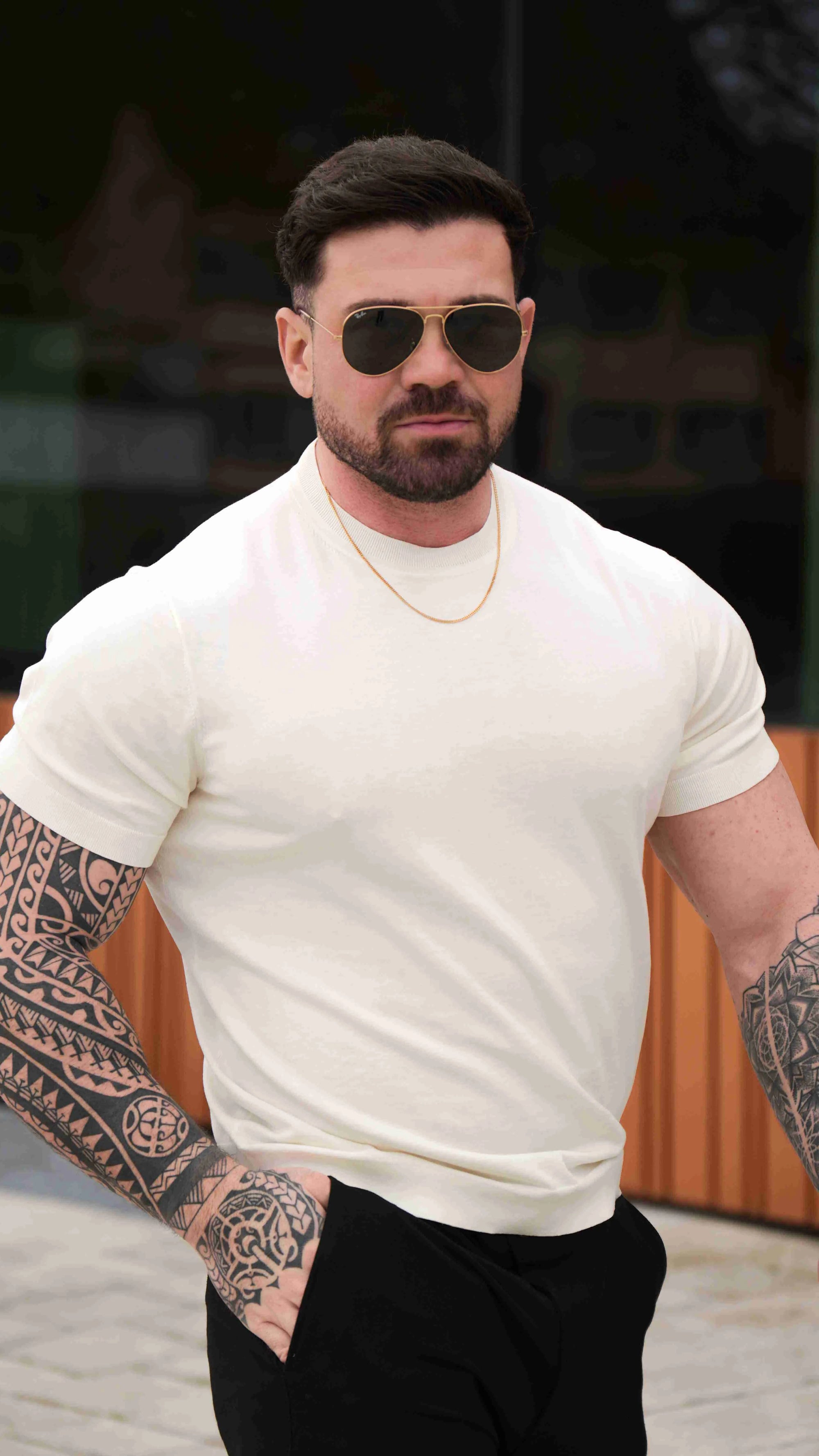 Men is wearing cream muscle-fit t-shirt.